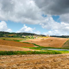 Obraz premium Mown Wheat Field on the Hills in Sicily