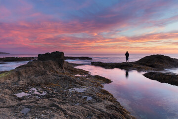 Lone man on the rocks at sunset at Treasure Island Beach in Laguna Beach, California, United States