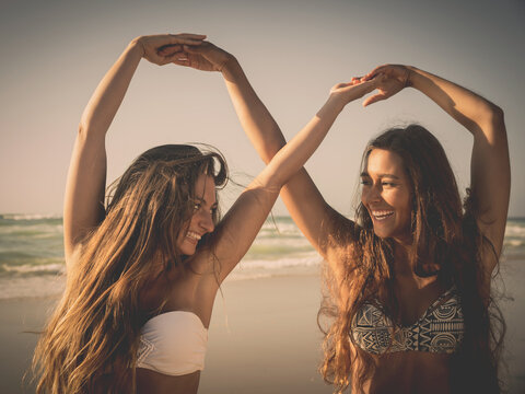 Beautiful girls in the beach giving her hands together