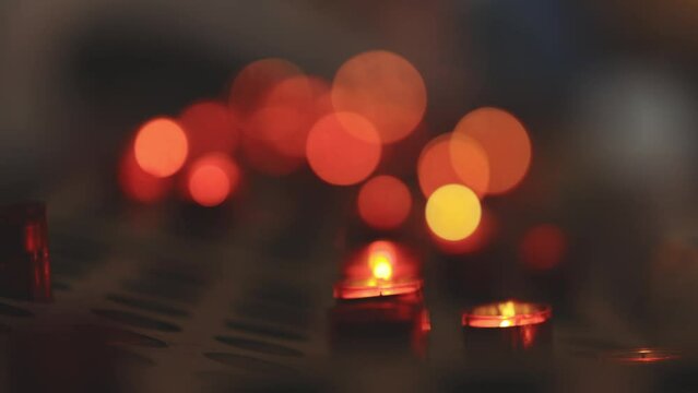 Red blurry candles light in church - bokeh effect