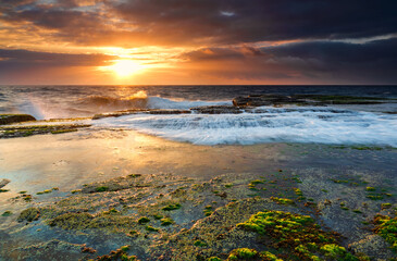 Low tide at north Narrabeen.  Bright green moss on the rocks as waves gently wash in.  Northern...