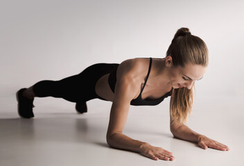 Studio shot of a young woman doing plank exercises
