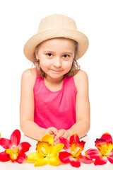 little girl and a bunch of exotic flowers on a table on a white background