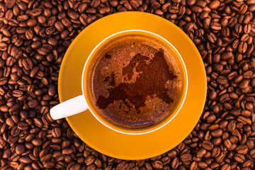europe map on fresh espresso with a beautiful crema and strewn mediumly roasted coffee beans