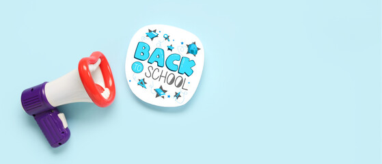 Megaphone and inscription BACK TO SCHOOL on light blue background with space for text