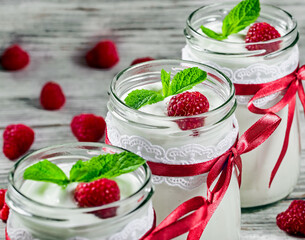 tasty yogurt with raspberries and mint in a glass jars, selective focus, macrro