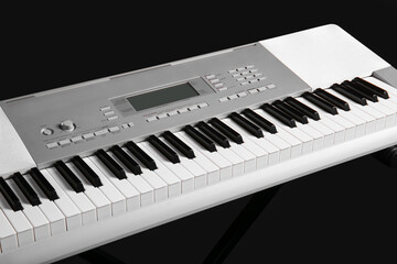 Modern synthesizer on black background, closeup