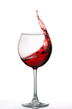 Glass with a splash of red wine isolated on white background. Clarity wineglass and wine. Aesthetics and delight. Relaxation. Luxury.