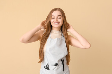 Female hairdresser on beige background