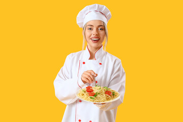 Female chef with tasty pasta on yellow background