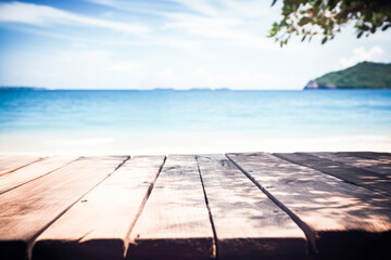 Fototapeta na wymiar Top of wood table with seascape, blur calm sea and sky at tropical beach background. Empty table ready for your product display montage.