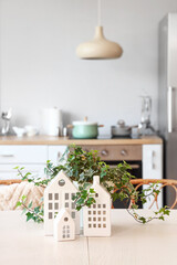 Table with stylish decor and houseplant in light kitchen, closeup