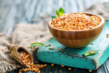 Bowl with dry yellow peas on old wooden table, selective focus.