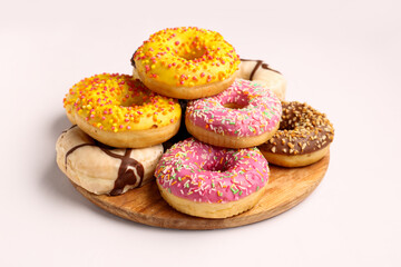 Board with sweet donuts on white background