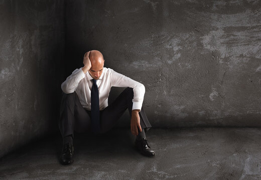Alone desperate businessman sits on the floor. solitude and failure concept