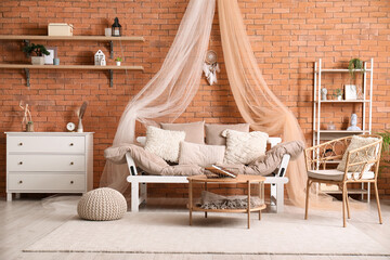 Interior of modern living room with sofa, chair, chest of drawers and dream catcher hanging on...