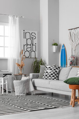 Interior of stylish living room with surfboard, synthesizer and sofa