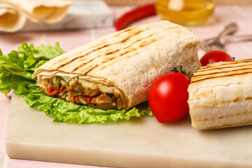 Board of tasty shawarma with lettuce and tomatoes on table