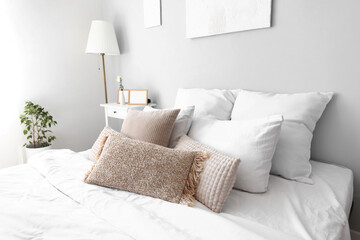 Cozy pillows on bed in light room