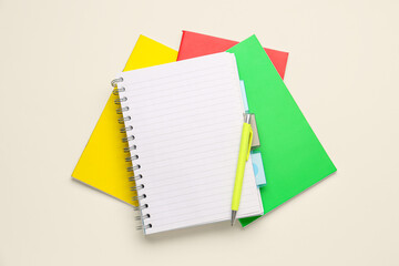 Stack of different notebooks and pen on white background