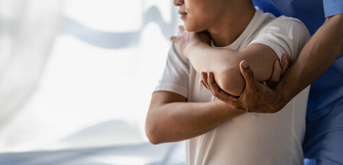 Close up patient hand doing stretching with physiotherapy to help in clinic room Therapist treats...