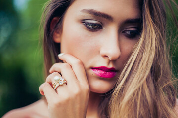 Portrait of beautiful girl with summer make-up. Stacking rings jewelry. Professional make-up and...