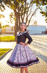 Fototapeta premium portrait smiling latin american young adult woman wearing huaso costume on the street