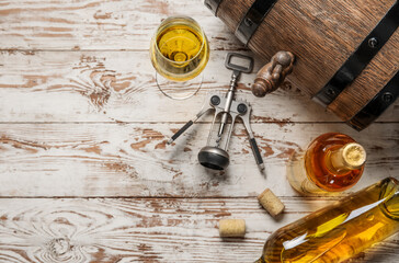 Obraz na płótnie Canvas Oak barrel, bottles and glass of exquisite wine on light wooden background