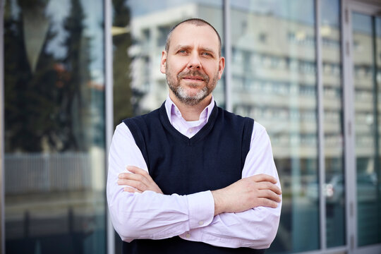 Middle aged businessman standing in front of his office.