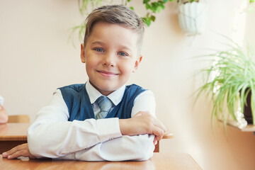 Happy schoolboy at school desk. Begining of learning.