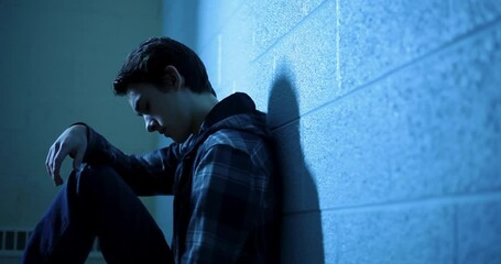Teenage Boy Sitting Alone in Dark Room – Concept of Sadness, Isolation, and Mental Health