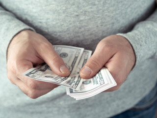 Hands counting dollars. Selective focus. Shallow DOF