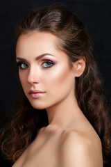 Fototapeta premium Close up beauty portrait of young pretty brunette model with multicolor smokey eyes make up posing over black background. Modern fashion make up. Studio shot