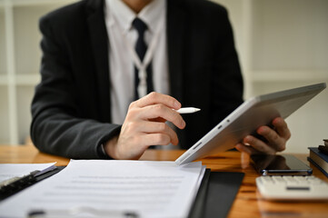 Close-up image of a professional businessman using his tablet at his desk.