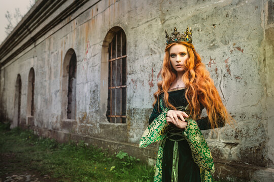 Portrait of a beautiful red-haired woman in green medieval dress