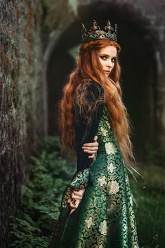 Red-haired woman in a green medieval dress near the castle