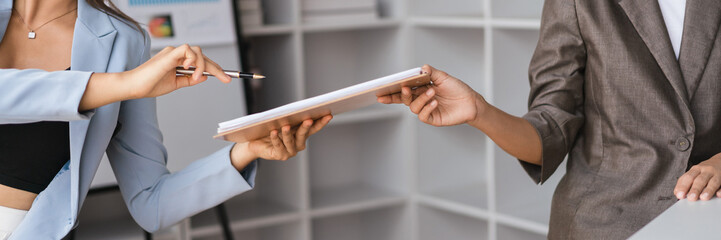 Businesswoman pointing and showing finance document to discussion about business data with partner