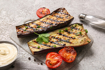 Delicious grilled eggplants, tomatoes and sauce on grey background
