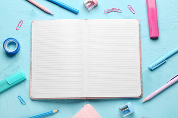 Notebook with different stationery on grunge blue background