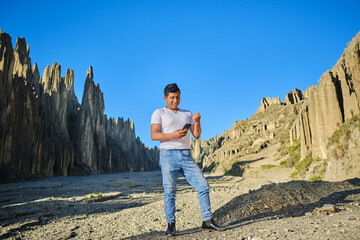 Fototapeta premium latin man on mountain trip looking at his cell phone