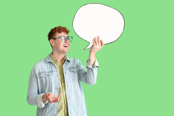 Young redhead man with blank speech bubble on green background