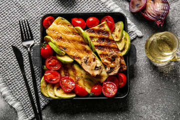 Baking dish with tasty grilled vegetables on grunge background