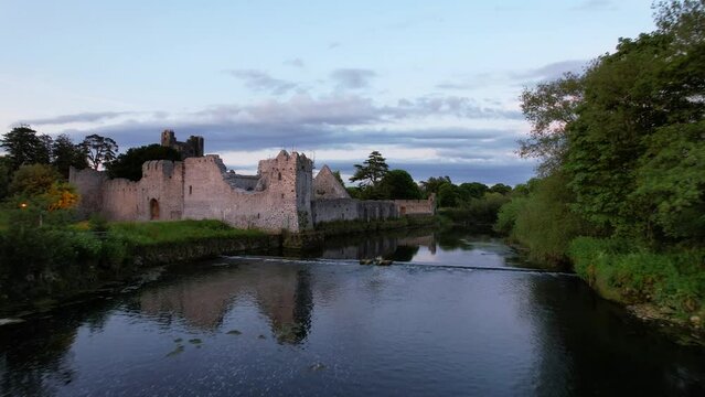 Desmond Castle ruins over Maigue River in Limerick County at sunset, Adare. Aerial