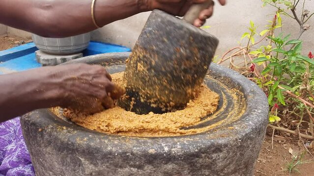 hand using a large authentic millstone, medieval utensil for grinding masala paste and cereals into flour