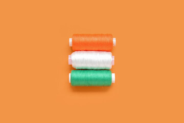 Indian flag made of thread spools on orange background