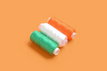 Fototapeta na wymiar Indian flag made of thread spools on orange background