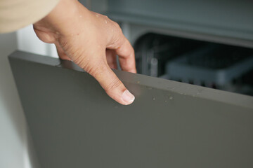 man's hand open drawer wooden in cabinet