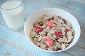 morning breakfast with corn flakes and glass of milk on table 