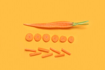 Slices of fresh carrot on orange background