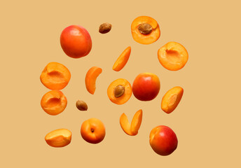 Flying fresh apricots with pieces on beige background